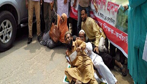 শিক্ষামন্ত্রীর গাড়ির সামনে শুয়ে শিক্ষকদের বিক্ষোভ